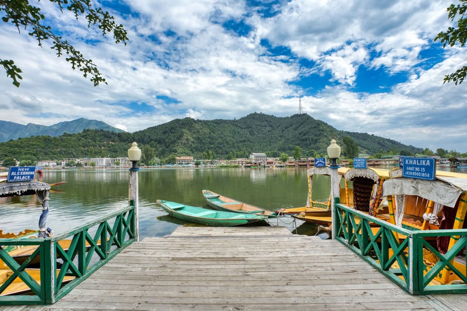 A wooden jetty and moored boats overlooking Dal Lake.