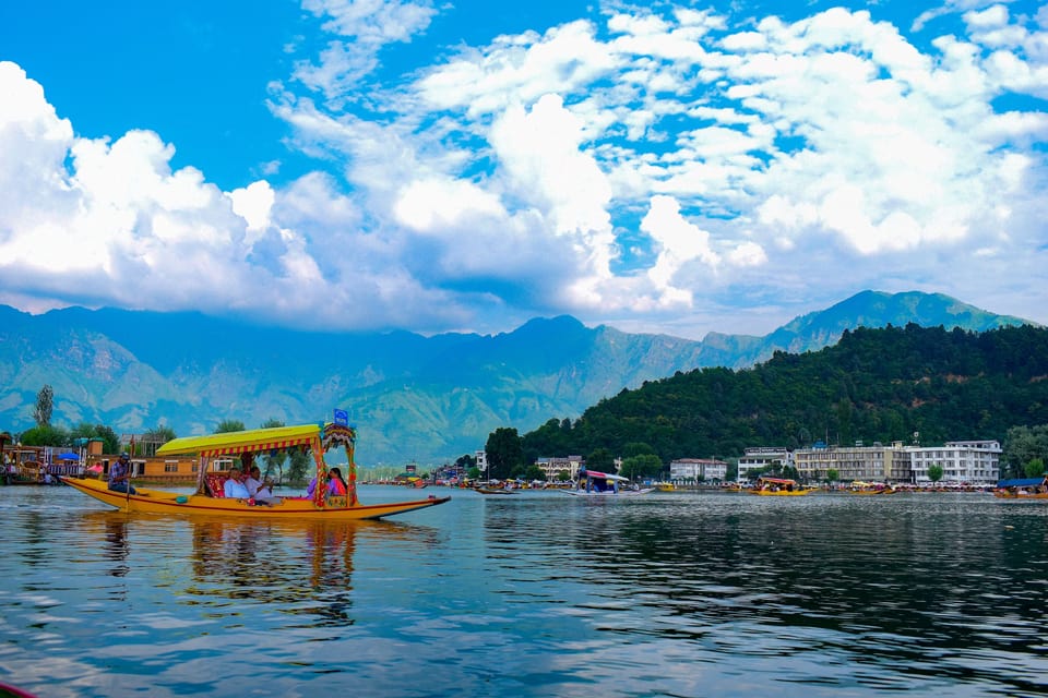 A colourful shikara beneath white clouds on Dal Lake in Srinagar.