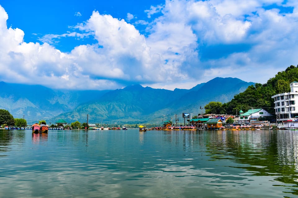 The waterfront and mountain backdrop viewed across Dal Lake.