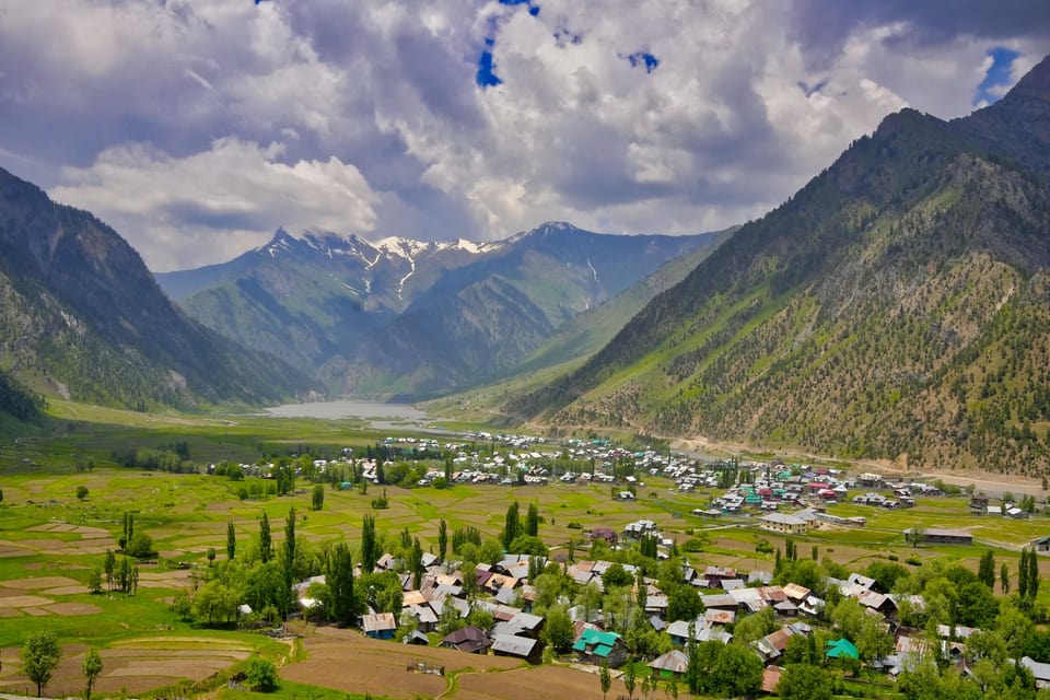A settlement and green fields surrounded by the mountains of Gurez Valley.
