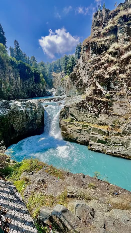 A cascade cutting through a rocky gorge at Aharbal.